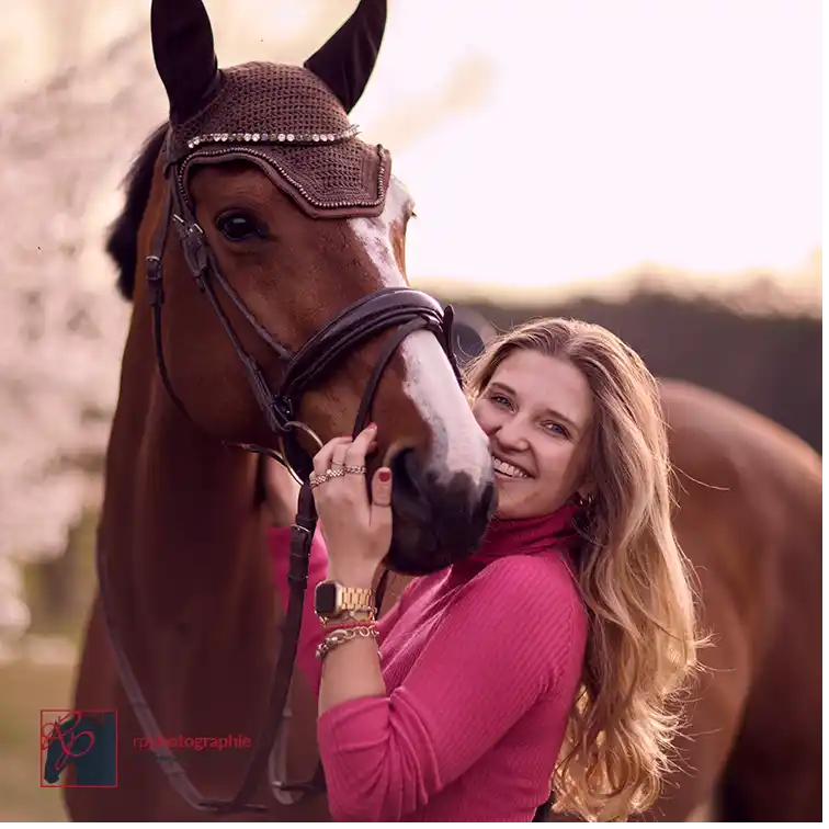 Junge Frau schmust mit ihrem Warmblut