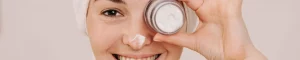 Frau mit Gesichtscreme in der Hand