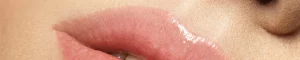 geschminkte Frauenlippen mit Gloss in Nude